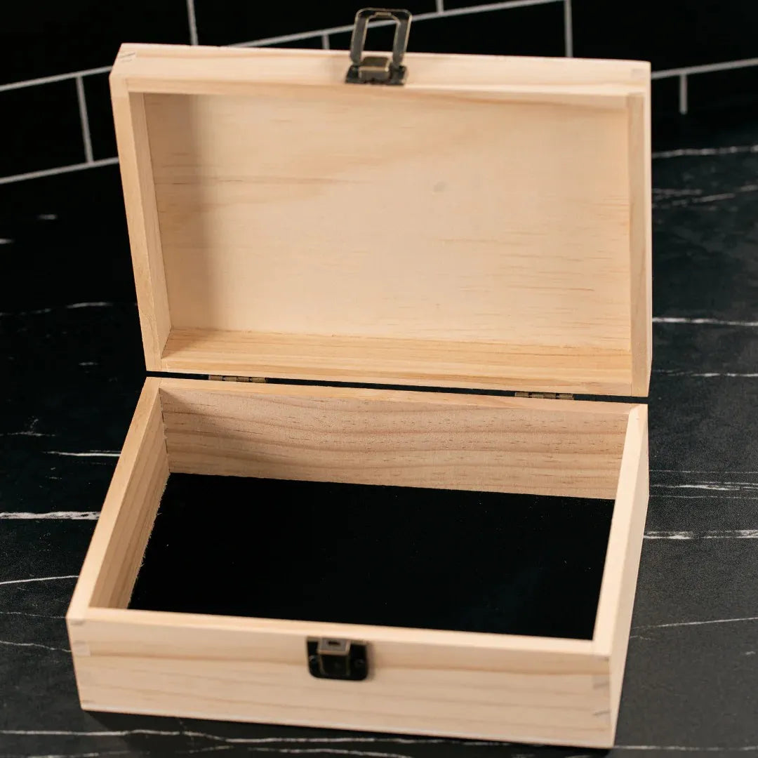 Wooden jewelry box with a black interior on a dark surface