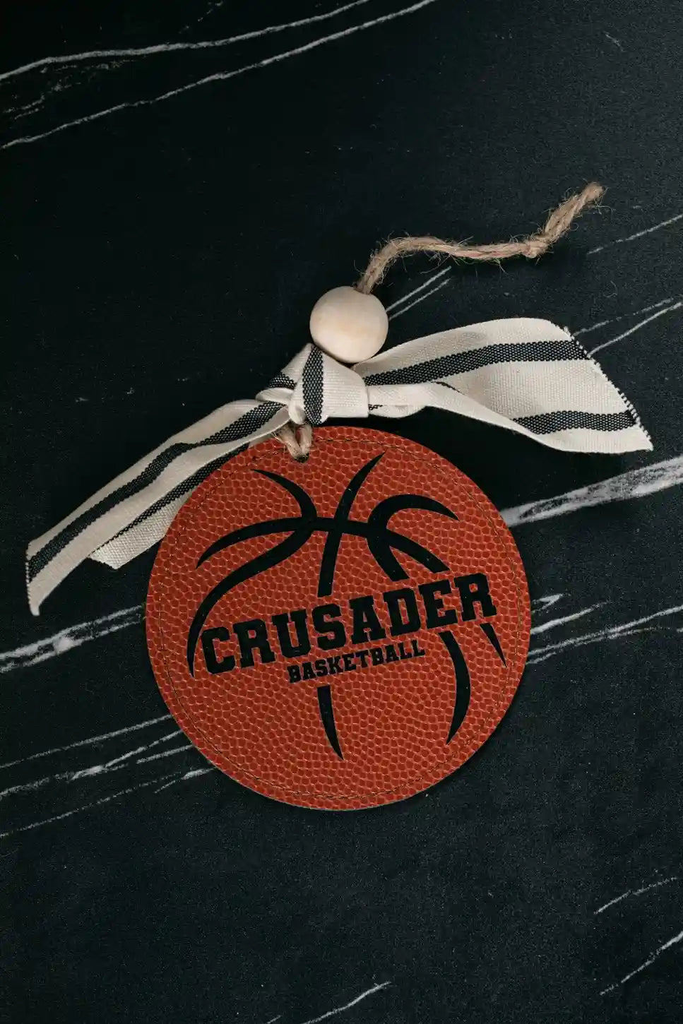 Decorative item with 'Crusader Basketball' design on a black background