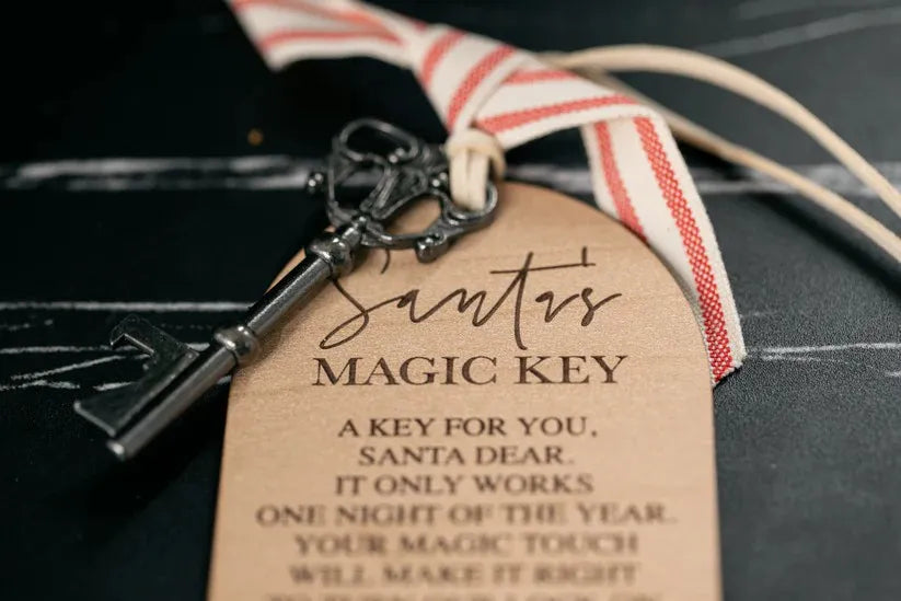 Decorative key with a tag labeled 'Santa's Magic Key' on a dark surface.